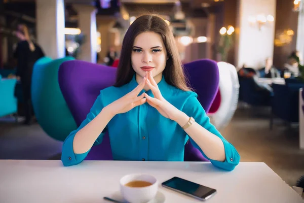 Donna d'affari rigorosa seduta a tavola in un caffè futuristico — Foto Stock
