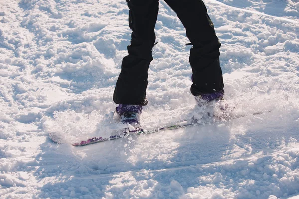 Jambes de snowboarder chevauchant sur une neige — Photo