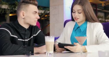 Modern genç çift birlikte bakarak kafede konuşurken tablet Pc