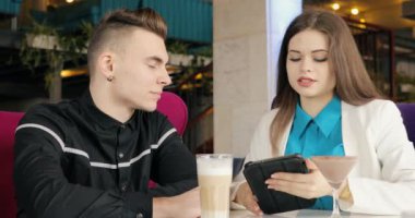 Modern genç çift birlikte bakarak kafede konuşurken tablet Pc