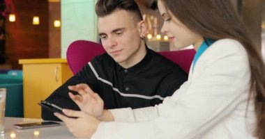 Modern genç çift birlikte bakarak kafede konuşurken tablet Pc