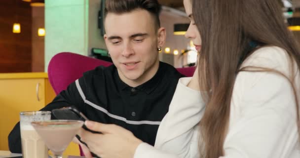 Moderna pareja joven hablando en la cafetería, mirando juntos en la tableta PC — Vídeos de Stock