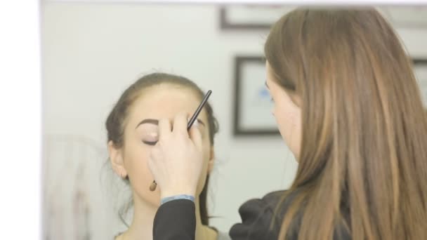 Zblízka vizážistka dělá make-up, barvení obočí pomocí řasenky — Stock video