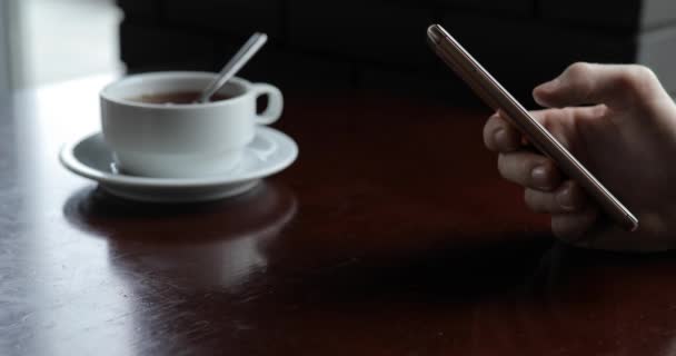 Αρσενική χέρι προσώπου χρησιμοποιώντας smartphone που κάθεται σε μια καφετέρια — Αρχείο Βίντεο