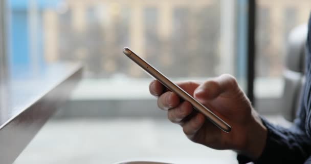 Persona mano masculina usando la pantalla táctil del teléfono inteligente sentado en un café — Vídeos de Stock