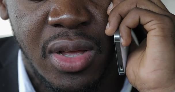 カフェ、口のクローズ アップでスマートな電話によって話しているアフリカの実業家 — ストック動画