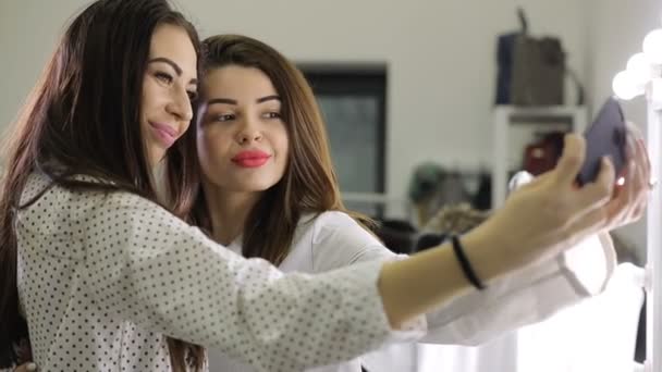 Смешные девушки делают селфи, используя смартфон в салоне красоты — стоковое видео