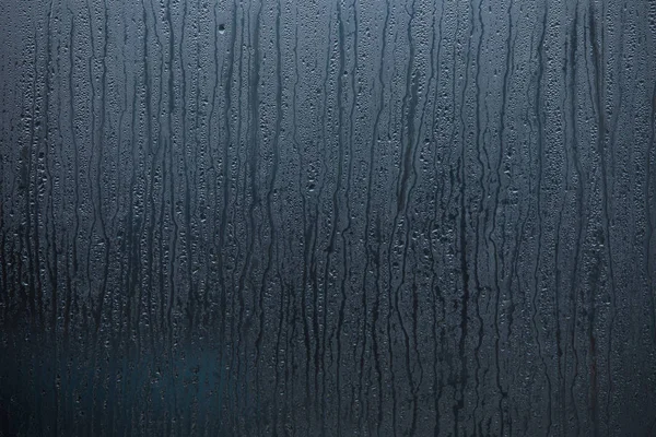 Мокрое окно с капельками воды — стоковое фото