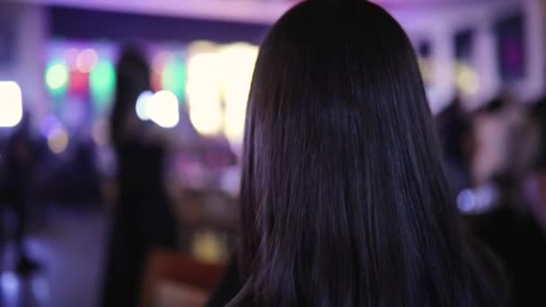 Дівчина фотографує, коли жінка танцює в нічному клубі, вид ззаду — стокове відео