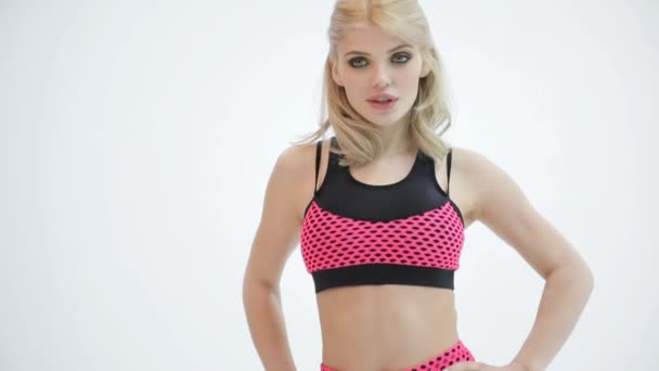 Mooie aantrekkelijke model in sportkleding poseren op een studio witte achtergrond — Stockvideo