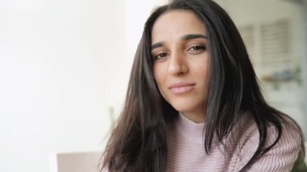 Attractive brunette woman portrait touching her hair sitting in a cafe — Stock Video