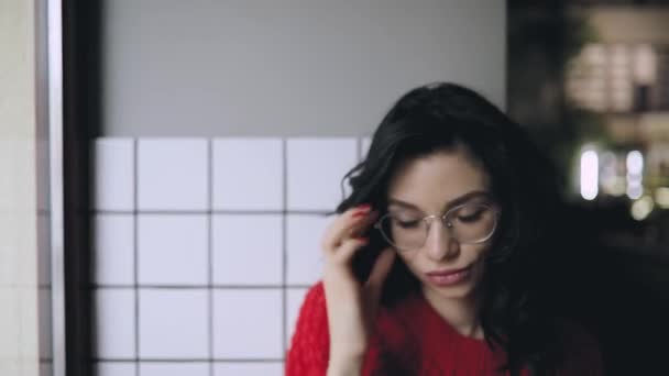 Mujer linda en gafas me mira con expresiones faciales — Vídeo de stock