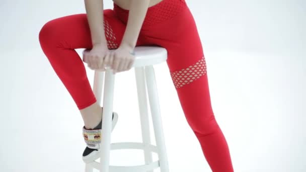 schönes attraktives Model in roter Sportbekleidung posiert vor einem weißen Studiohintergrund
