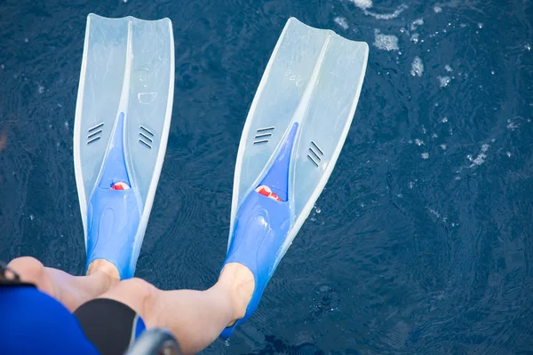 Vrouwelijke benen met flippers boven de zee — Stockfoto