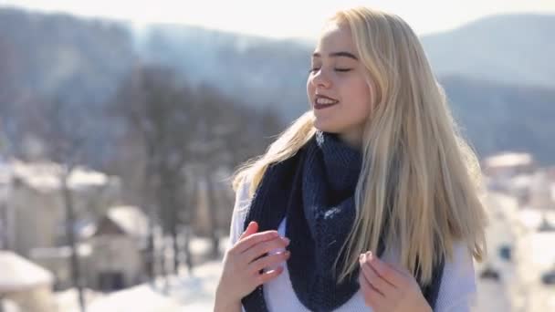 Giovane donna in maglione e sciarpa in posa su un ponte durante la giornata invernale — Video Stock