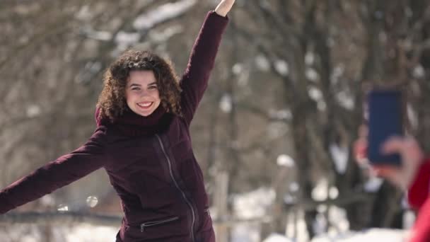 Mobiele fotografie, krullend haar gelukkige vrouw poseren buiten — Stockvideo