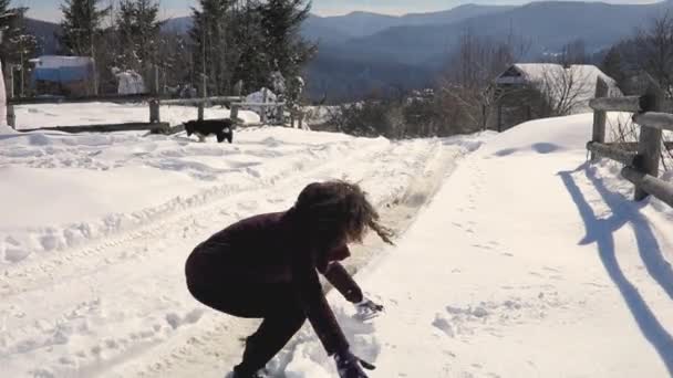 Glad ung kvinna kasta snö i vinter snötäckta bergslandskap — Stockvideo