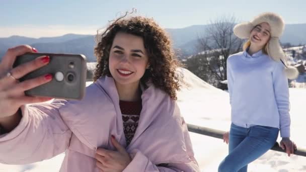 Filles amis faisant photo mobile au paysage de montagne enneigé — Video