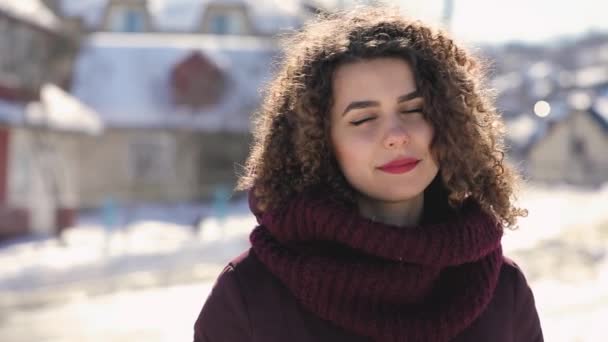 Gelukkig lachende krullend haar vrouw dicht omhoog portrait in de besneeuwde dag, slowmotion — Stockvideo