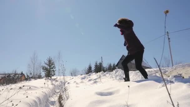 Liberdade, mulher feliz pulando sobre o fosso em dia ensolarado nevado — Vídeo de Stock