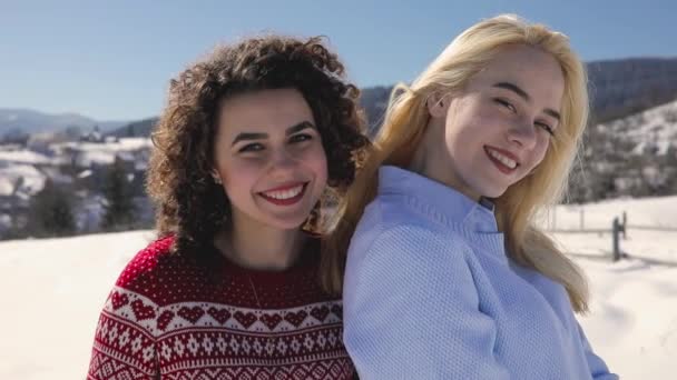 Ευτυχισμένος αστεία κορίτσια φίλοι κάθεται στο φράχτη, χιονισμένο βουνό τοπίο γύρω από το — Αρχείο Βίντεο