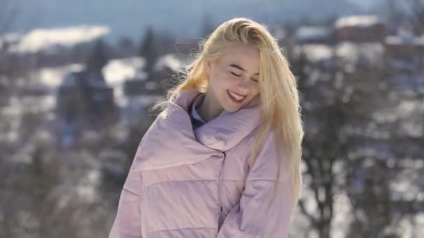 Porträtt av glada leende flicka gungade hår vid snötäckta berg landsbygden — Stockvideo