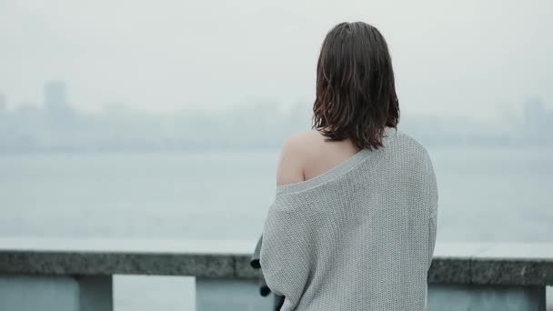 Femme sous parapluie regardant vers le paysage de la ville — Video