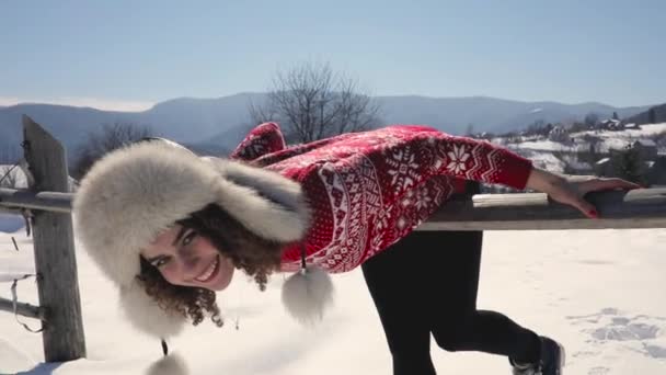 Ung glad kvinna i skandinaviska tröja åtnjuter på snötäckta bergslandskap — Stockvideo