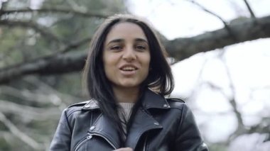 Güzel kadın parkta ağaç altında gülüyor