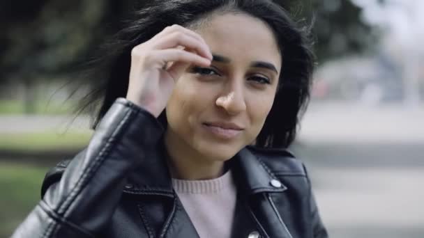 Atractiva mujer sentada en el banco apoyada cabeza a mano — Vídeos de Stock