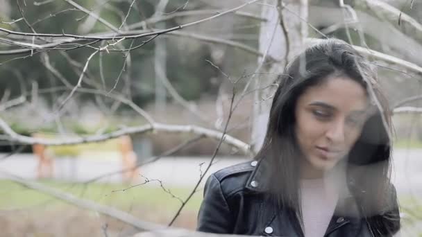 Jolie femme portrait entre branches d'arbres — Video