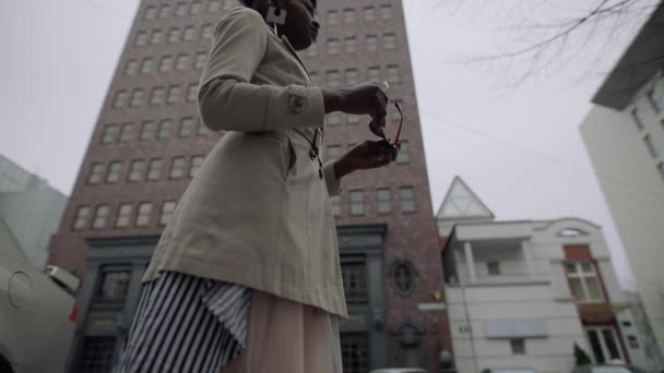Une femme à la mode porte des lunettes de soleil rouges dans le centre-ville urbain — Video