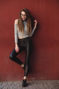 Kırmızı duvar arka planı poz dreadlocks ile şık kadın