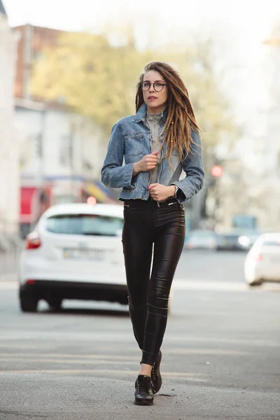 Street style, fashionable woman walking in city on road