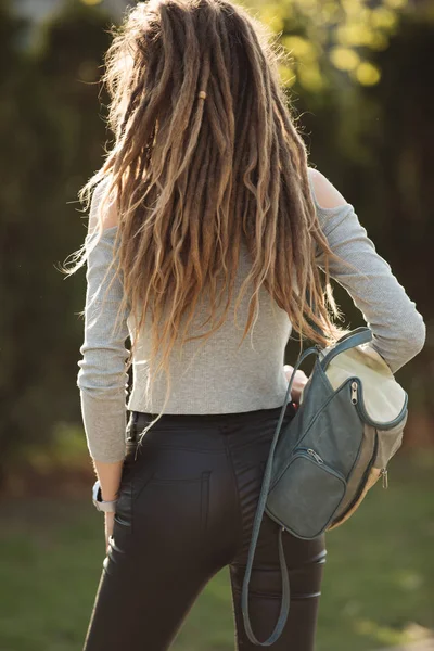 Tasche auf dem Rücken der Frau, Mädchen mit Dreadlocks-Frisur — Stockfoto