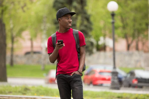 Ember a rózsaszín póló segítségével okos telefon, a város utca — Stock Fotó