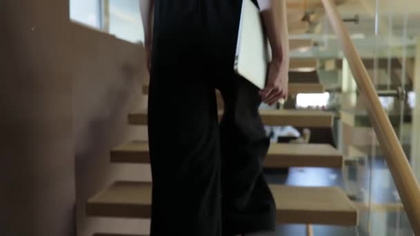 Businesswoman carry laptop up on stairs to office — Stock Video