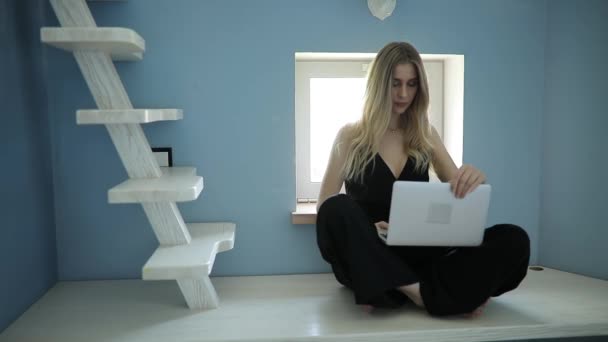 집에서 편안하게 노트북을 가지고 일하는 섹시 한 여자 — 비디오