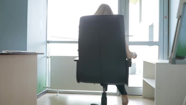 Sexig kvinna avkopplande roterande på stol i office — Stockvideo