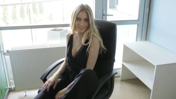 Сексуальная женщина расслабляется вращаясь на стуле в офисе — стоковое видео