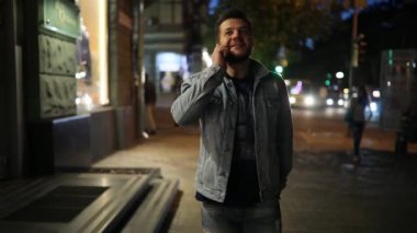 Gece boyunca yürüyüş smartphone tarafından sokak konuşan adam
