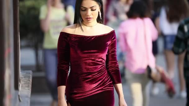 Luxury woman in burgundy dress walking in city street — Stock Video