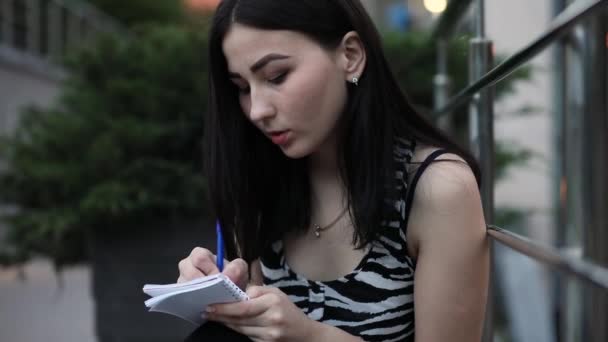 十几岁的女孩写笔记在抄写本 — 图库视频影像