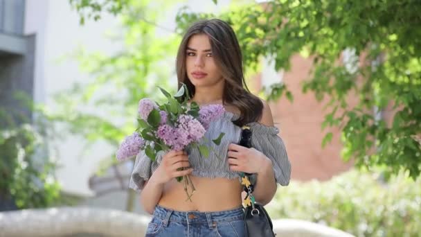 Glückliche Frau, die fliederfarbene Blumen hält — Stockvideo