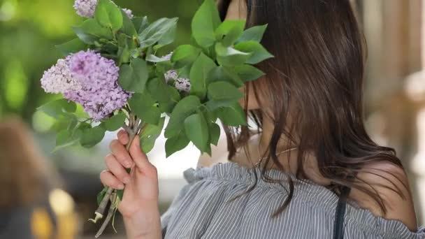 Mujer feliz disfrutando del olor a lila — Vídeos de Stock