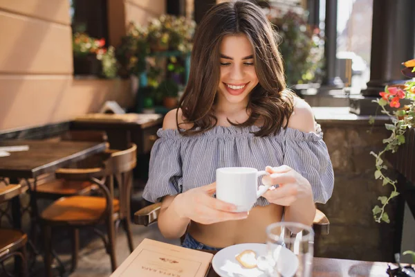Tutma fincan çay restoranda gülümseyen genç ve güzel kadın — Stok fotoğraf