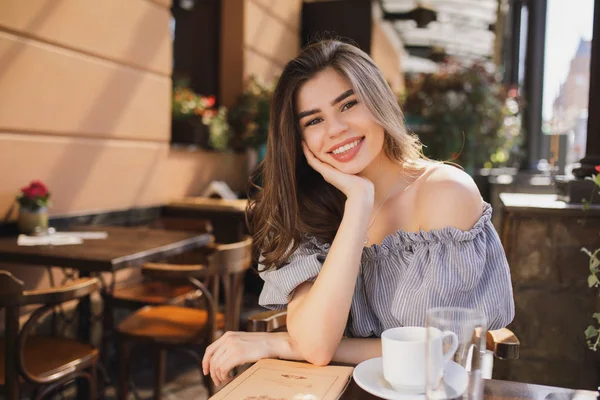 Kaunis nainen istuu ravintolassa nojaten pää kädessä — kuvapankkivalokuva