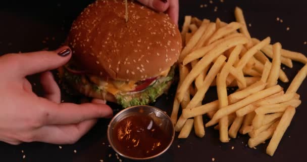 Comer hambúrguer, fundo preto — Vídeo de Stock