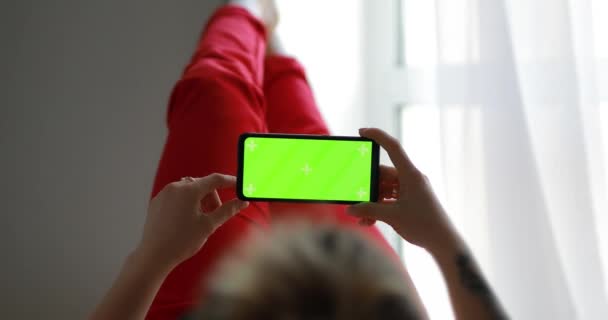 Donna che utilizza lo schermo verde mockup di smartphone sdraiato a casa — Video Stock