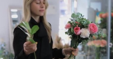 Çiçekçi kadın bir buket çiçek yapar.